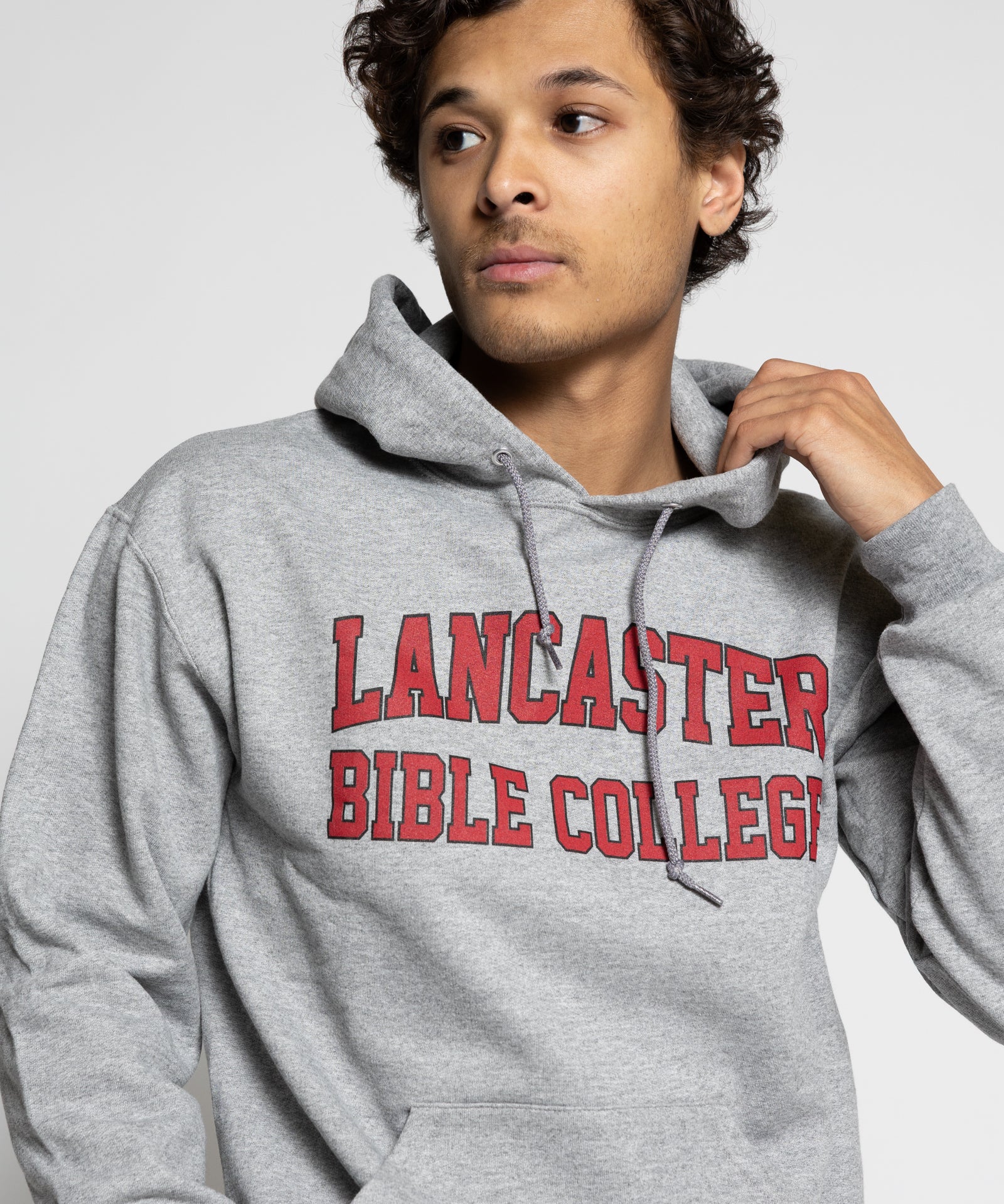 man wearing a gray hoodie with 'Lancaster Bible College' text on a light gray background