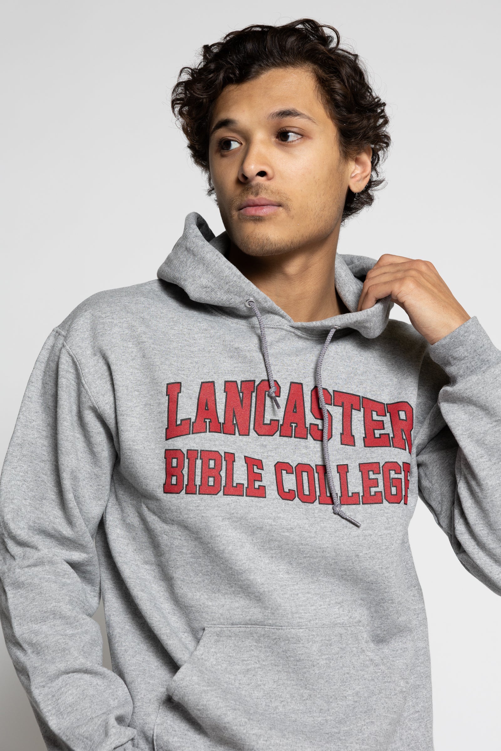 man wearing a gray hoodie with 'Lancaster Bible College' text on a light gray background